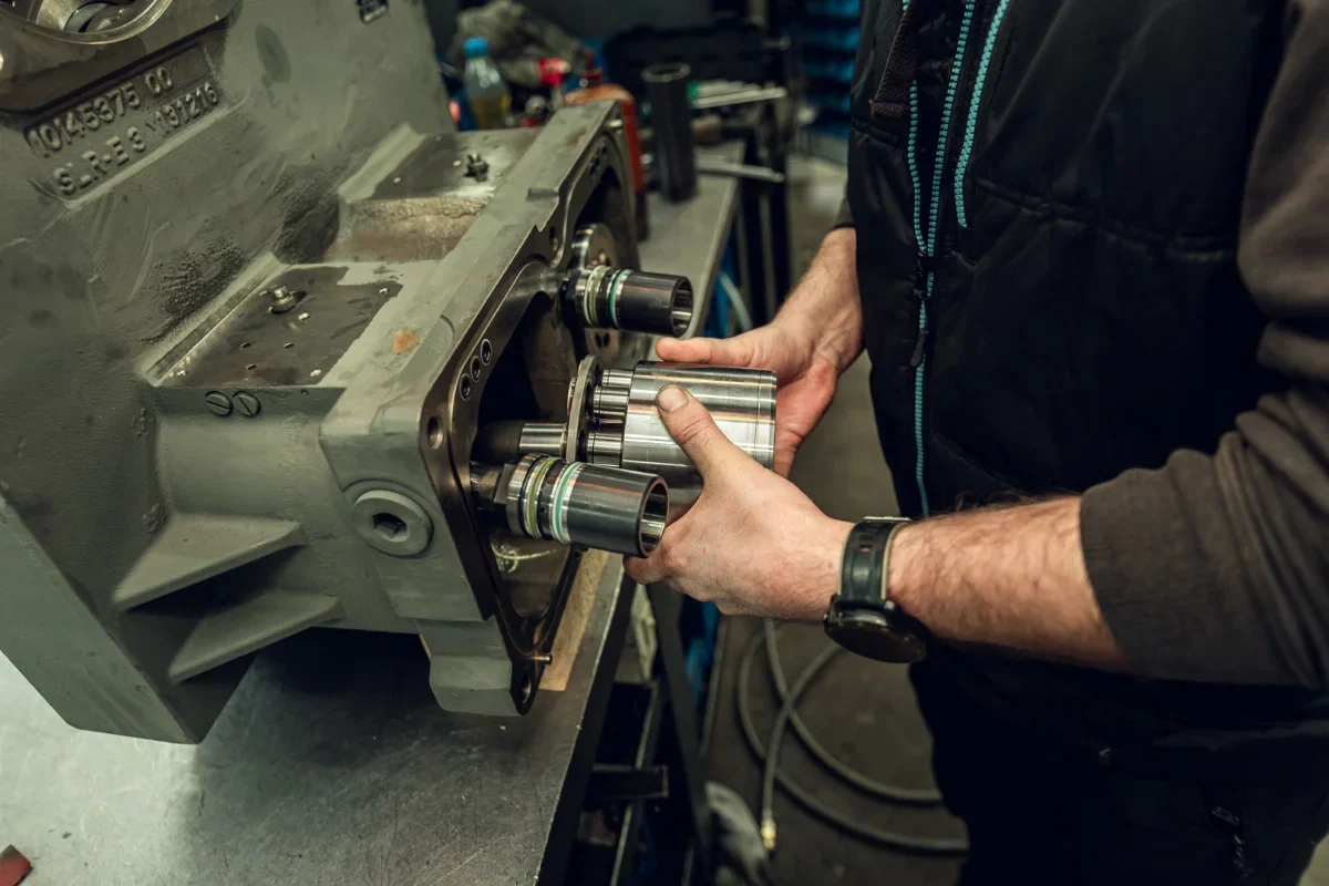 Regeneracja pompy hydraulicznej – mechanik wyjmuje zespół tłoczków z korpusu pompy w warsztacie
